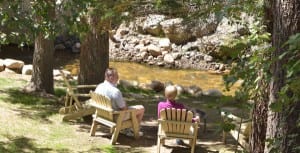 two people sitting in chairs in front of the blackhawk river