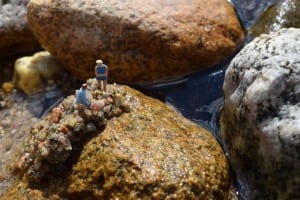 Two tiny figurines on a rock