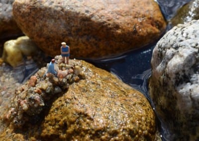 Two tiny figurines on a rock