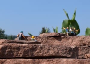 5 tiny figures standing on a rock