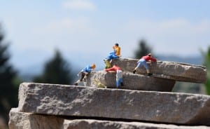 five tiny figures climbing rocks