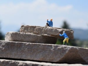 two tiny figures climbing rocks