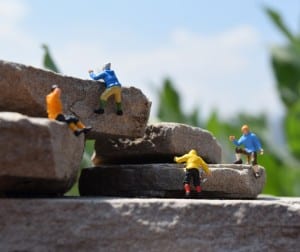 four tiny figures climbing rocks.