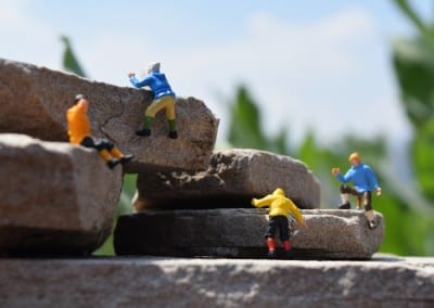four tiny figures climbing rocks.