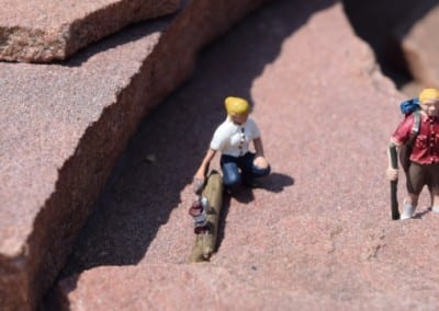 two tiny figures on a rock