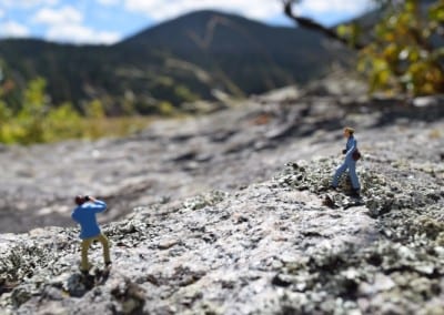 two tiny figures on a rock