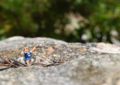 a tiny figure on a rock pointing